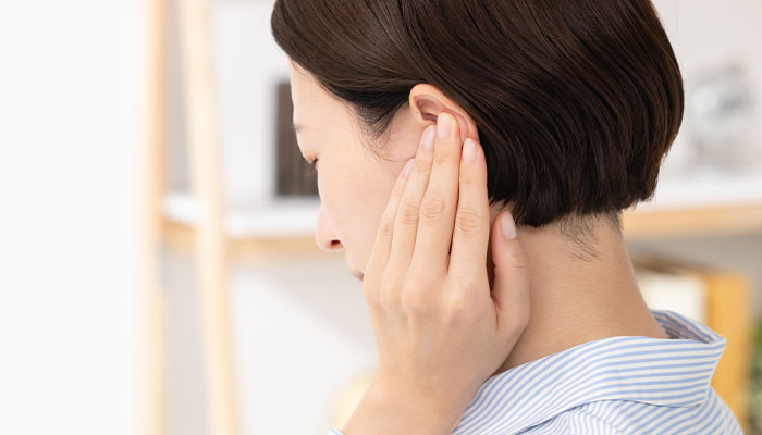 みみを押さえる女性