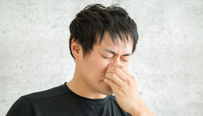 鼻を押さえる男性